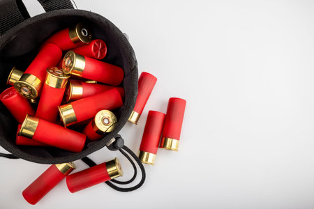 Black bag and shotgun shell  ammunition for practicing sports on white background