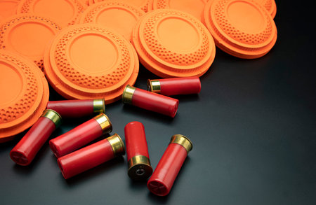 Clay disc flying targets and shotgun bullets on black background ,Clay Pigeon target