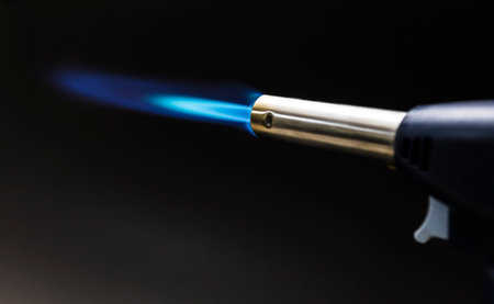 Blue flame from a gas torch burner on black background