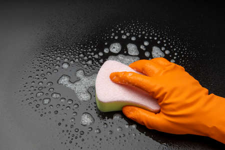 A hand in rubber glove cleaning on blackの写真素材