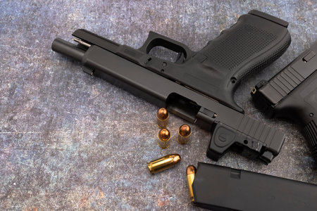 .45 Semi automatic pistol handgun and bullet magazine on texture background , Lock and open slide...