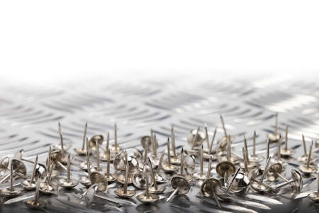 A metal thumbtacks or push pins on daimond plate , Concept of overcoming obstacles to achieving success , Can be used as a background , Symbol of never giving upの写真素材