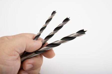 Spiral drill bit in a man's hand , The  carpenter select the drills