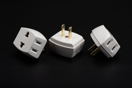 3 way extension and adaptor plugs on black background