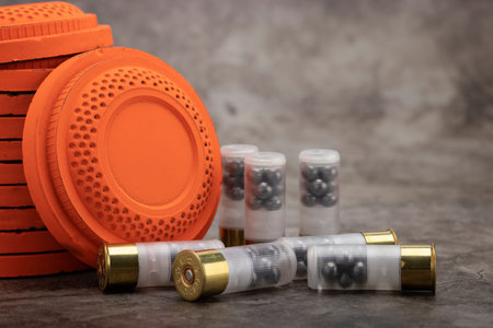 Clay disc flying targets and shotgun shells on texture background ,Clay Pigeon target game