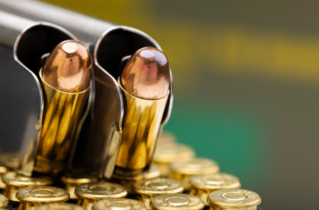 .45 ACP bullet pistol gun with green army ammo box background