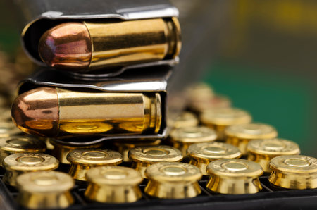 .45 ACP bullet pistol gun with green army ammo box background