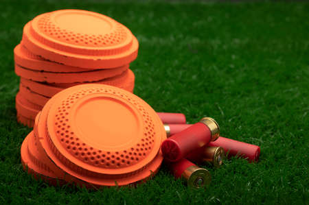 Clay shooting target and shotgun bullets on green background ,Clay Pigeon target gameの写真素材