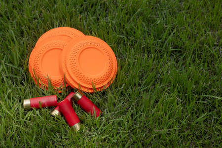 Clay shooting target and shotgun bullets on green background ,Clay Pigeon target gameの写真素材