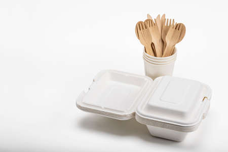 Wooden spoon and fork with knives and bagasse food box   , disposable tableware on white background. Eco-friendly materialsの写真素材