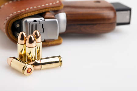Ammunition Bullets with pistol hand gun in leather holster backgroundの写真素材