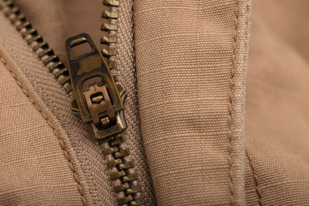 Close up of metal zipper and clothing brown pattern backgroundの写真素材