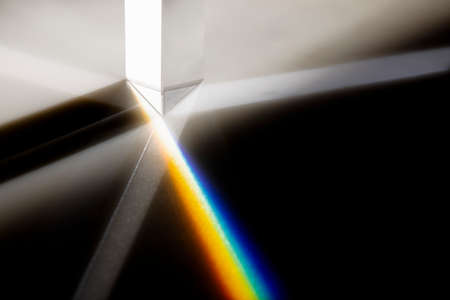 Triangular Prism dispersing sun beam splitting into a spectrum on white backgroundの写真素材