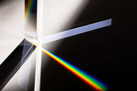 Triangular Prism dispersing sun beam splitting into a spectrum on white backgroundの写真素材