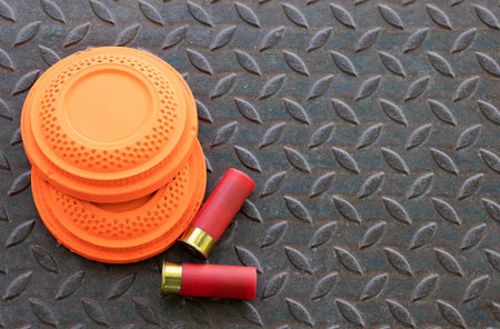 Clay shooting target with shotgun bullet on checkered plate background , gun shooting game