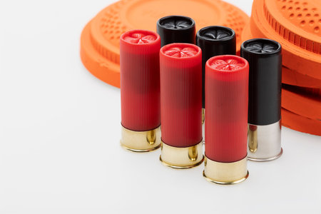 Red and Black shotgun shell with clay pigeon target on white background , Gun shooting game