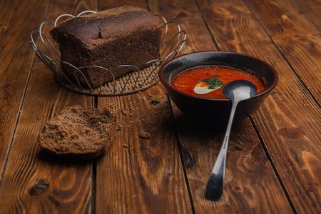 Soup in a clay pot on the table is made of woodの写真素材