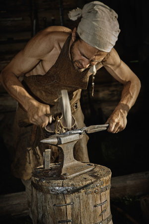 Molten metal handles medieval blacksmith on the anvilのeditorial素材