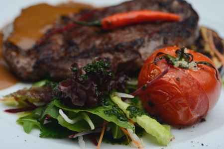 A large piece of roasted veal with tomatoes and courgettesの写真素材