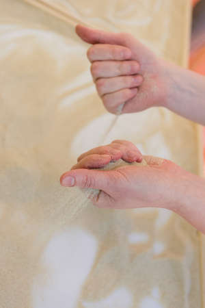 Creating a pattern on dry sand hands. Hand pours pesok- artistic creativityの写真素材