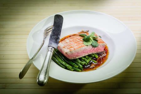 cooked fish in a plate decorated with verdureの写真素材