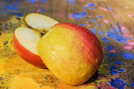 Art background- cut apple lies on the paint mixing board