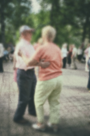 Dance older person: retro photo background. Old people- active dancing couple in the park.の写真素材