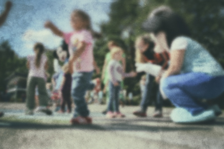Old photo- blurred background people. Fast motion: active play - activities for children outdoors in the park.の写真素材
