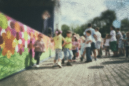 Old photo- blurred background people. Fast motion: active play - activities for children outdoors in the park.の写真素材