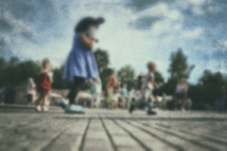 Old photo- blurred background people. Fast motion: active play - activities for children outdoors in the park.の写真素材