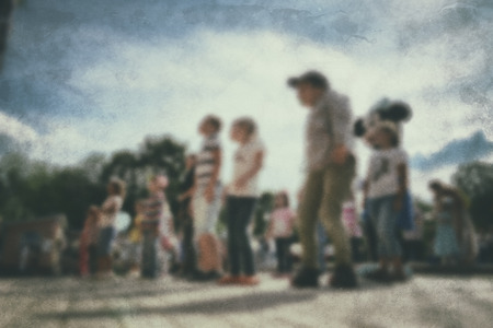 Old photo- blurred background people. Fast motion: active play - activities for children outdoors in the park.の写真素材