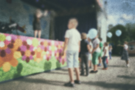 Old photo- blurred background people. Fast motion: active play - activities for children outdoors in the park.の写真素材