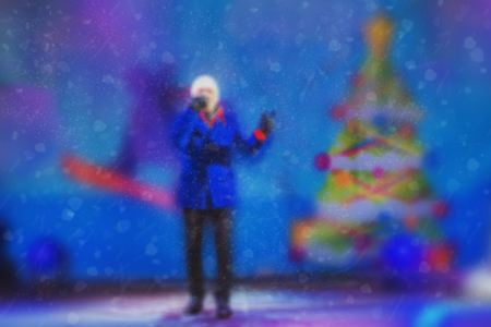 Blurred background of a winter landscape - people in the park to celebrate Christmas holiday. The performance of the artists on stage. Actors and musicians entertain the guests.の写真素材