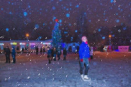 Blurred background of a winter landscape - people in the park to celebrate Christmas holiday. The performance of the artists on stage. Actors and musicians entertain the guests.の写真素材