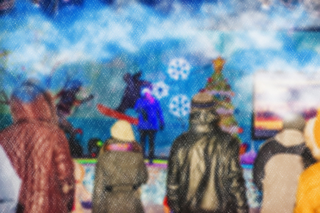 Blurred background of a winter landscape - people in the park to celebrate Christmas holiday. The performance of the artists on stage. Actors and musicians entertain the guests.の写真素材