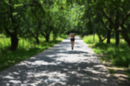 Sport- training outdoors in summer park. Workout young man performs exercise. Blurred background - a practical lesson on the playgroundの写真素材