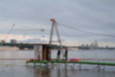 Blurred background active days on the river. Wakeboarding - riding people on the board through the water using rope.の写真素材