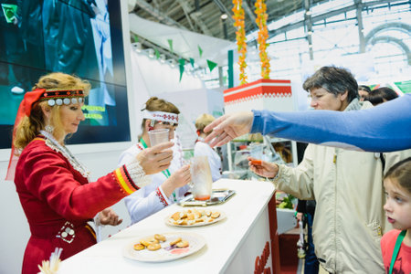 Moscow, Russia, Expocenter VDNH - OCTOBER 4-7, 2017: Russian agro-industrial exhibition "Golden autumn". Business stand. Mari El Republics- representatives treat visitorsのeditorial素材