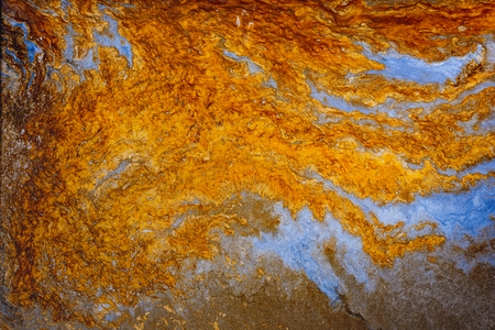 Fluid art. Abstract artwork- stain, splashes, smearing the dye. Liquid acrylic- color blot. Pigment water background- gold colorの写真素材