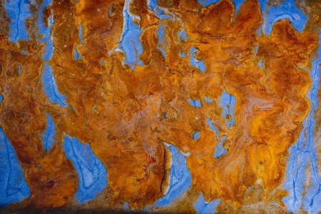 Fluid art. Abstract artwork- stain, splashes, smearing the dye. Liquid acrylic- color blot. Pigment water background- gold colorの写真素材