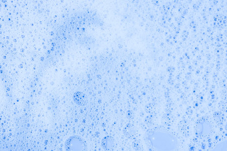Soap bubbles- foam color background. Suds top view- liquid shampoo. Soapsuds- multicolor stains drip