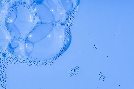 Soap bubbles- foam color background. Suds top view- liquid shampoo. Soapsuds- multicolor stains drip