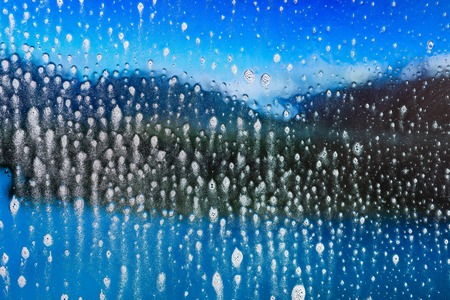 Background wet- raindrop realistic. Water splash shower- bad weather. Window- soap foam. Rainwater- liquid splash abstractの写真素材
