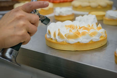 Hands of the cook- decoration of a sweet cake. Chef- creative workの写真素材