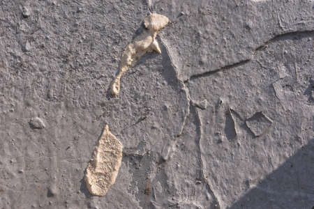Destroyed plaster on the wall. Numerous cracks, chips and peeling paint. Texture- damaged materialの写真素材