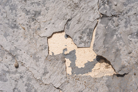 Destroyed plaster on the wall. Numerous cracks, chips and peeling paint. Texture- damaged material
