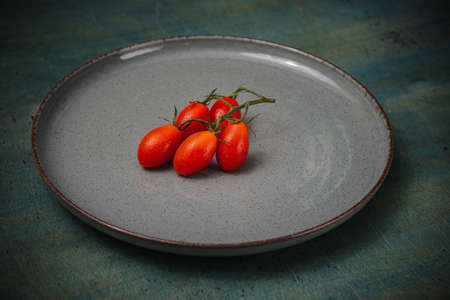 Tomatoes in a plate on the table. Food for vegans- cooking in the kitchenの写真素材