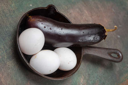Food set for cooking scrambled eggs. Cast-iron frying pan on the table. Kitchen utensilsの写真素材
