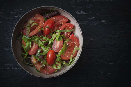 Beautiful food for vegans. Tomato slices decorated with green saladの写真素材