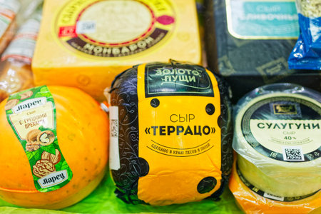 Various types of cheese on display at a grocery store.のeditorial素材